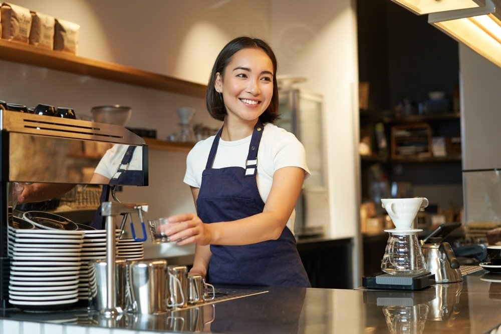 Smiling,Girl,Barista,In,Cafe,,Preparing,Cappuccino,In,Coffee,Machine,