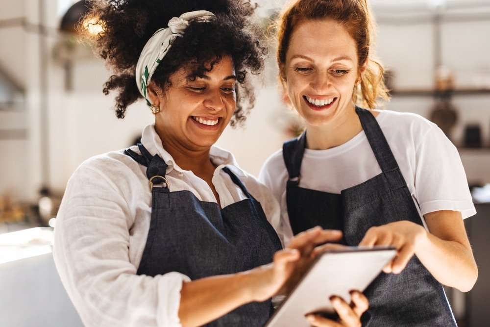 Happy,Restaurant,Workers,Stand,Side,By,Side,,Focused,On,The