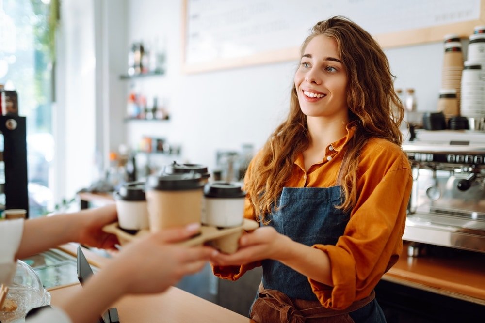 Takeaway,Food,Concept.,A,Beautiful,Female,Barista,Gives,To go,Coffee