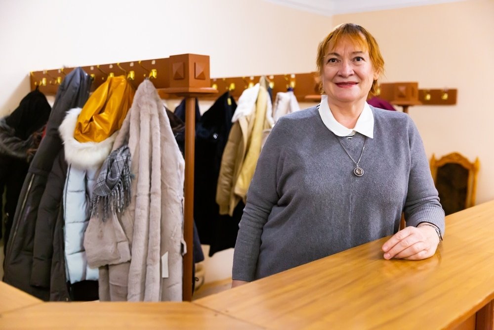 Portrait,Of,Polite,Senior,Woman,Working,In,Cloakroom,In,Museum,