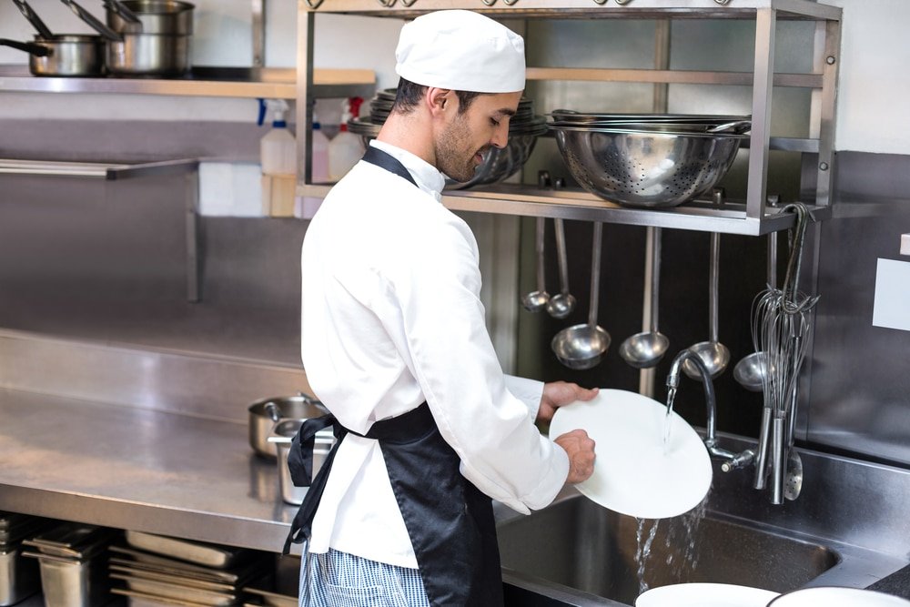 Handsome,Employee,Doing,Dishes,In,Commercial,Kitchen