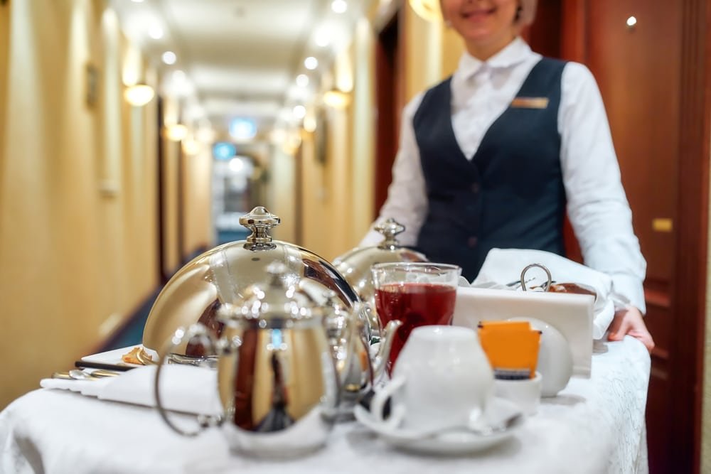 Waitress,In,Uniform,Delivering,Tray,With,Food,In,A,Room