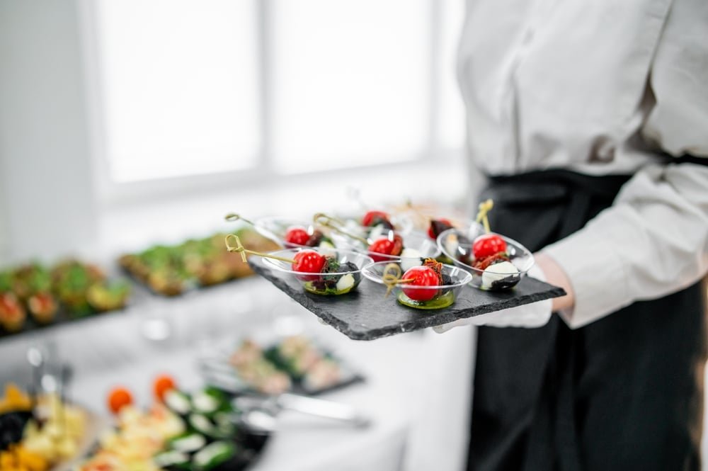 A,Waiter,In,A,White,Shirt,And,Black,Apron,Holds