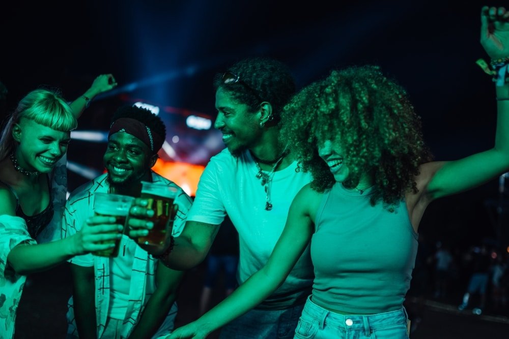 Group,Of,Cheerful,Young,Friends,Toasting,With,Beer,And,Dancing